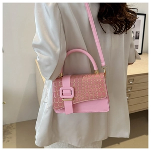 Detailed view of a pink stone pattern crossbody bag worn by a model in a white blazer