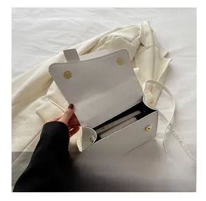 Detail show of white stone texture mini square bag interior holding a smartphone