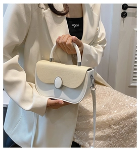 Detailed view of the chic cream-white crossbody bag with woven fabric texture and top handle