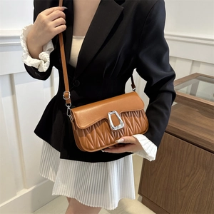 Brown retro pleated square shoulder bag with silver buckle worn by a fashion model