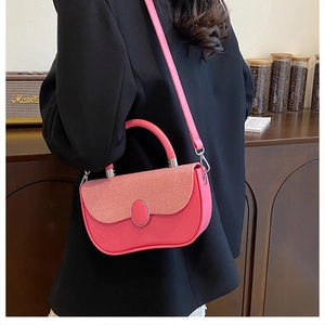 Pink crossbody bag with textured fabric flap shown on model in a cozy interior setting