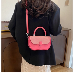 Pink crossbody box bag with woven texture lid styled on a model in a black blazer