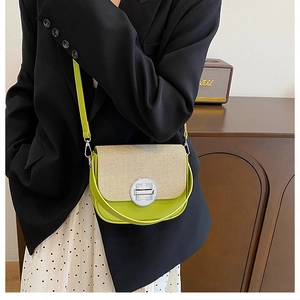 Detail of lime green and beige patchwork box bag with silver metal lock on model