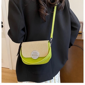 Detail of crossbody bag with neon green leather stitching and round metal clasp