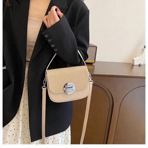 Detail of cream box bag showing striped fabric texture and silver circular swivel lock