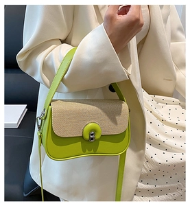 Dettaglio borsa a tracolla in pelle verde neon con patta intrecciata beige e fibbia