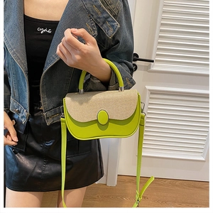 Detail of lime green crossbody bag with straw patchwork and oval decorative buckle