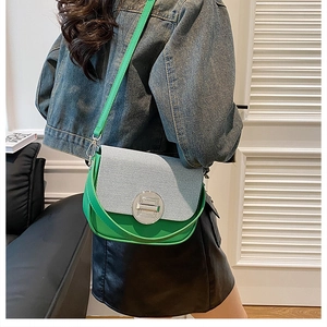 Detail of green and white woven shoulder bag with silver round metal clasp on model