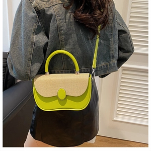 Model view of a green saddle bag with beige woven flap and silver metal buckles