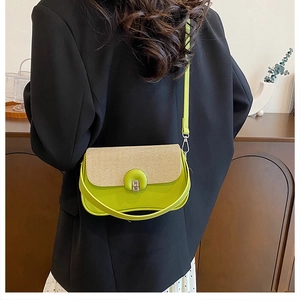 Dettaglio della borsa a tracolla verde e beige con chiusura in metallo su una modella