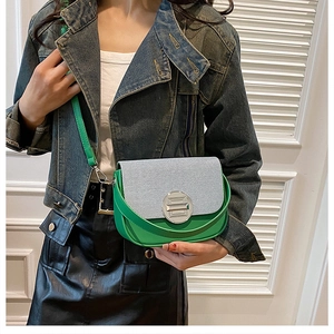 Detail of a color-block crossbody box bag with green leather and striped texture fabric