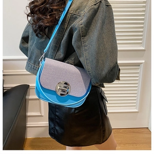 Blue box bag with purple woven flap and silver metal buckle shown on model shoulder