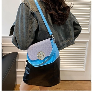 Blue leather shoulder bag with striped fabric detail shown as worn by a model