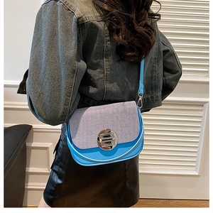 Detail view of sky blue box bag with striped texture worn over the shoulder by a model