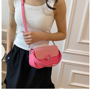 Dettaglio della borsa a tracolla fucsia con patta testurizzata e chiusura in pelle