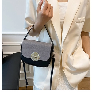 Detail view of contrast stitching handbag with gold clasp and textured fabric cover