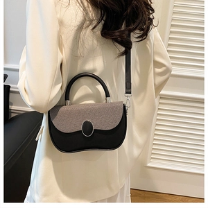 Rear view of a model wearing a two-tone crossbody bag with black leather and gray fabric