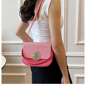 Detail showing fuchsia box bag with textured flap and silver round buckle on shoulder
