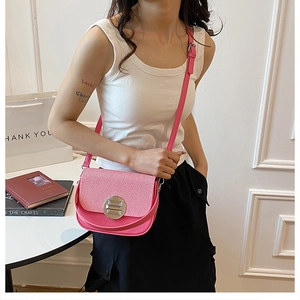 Detail of pink faux leather box bag featuring lychee texture and silver round lock