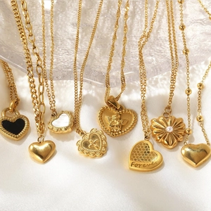 Colliers en acier inoxydable doré avec pendentifs cœur sur fond en soie blanche