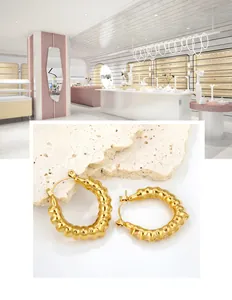 Makro-Detail goldener Creolen mit einzigartig gehämmerter, zerknitterter Metalltextur