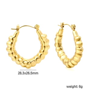 Goldene Creolen mit Wellentextur im Retro-Stil für einen minimalistischen Look