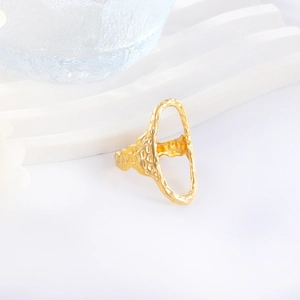 Gros plan d'une bague géométrique dorée avec texture martelée et design ovale ajouré