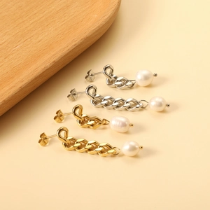 Dettaglio delle orecchini a catena oro e argento con eleganti perle bianche rotonde