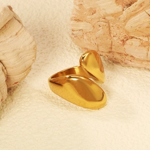 Macro shot of gold-plated stainless steel ring with asymmetric teardrop design on rocks