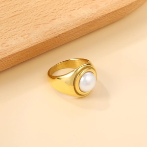 Detail of a large white pearl embedded in a wide polished 18K gold stainless steel ring