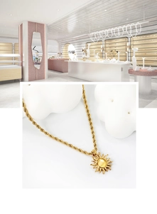 Detailed macro view of an 18K gold plated sun pendant with a twisted rope chain necklace
