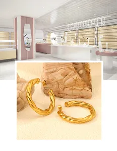 Detailed shot of 18K gold twist hoop earrings with textured spiral metal pattern