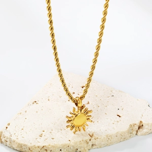 18K gold plated stainless steel sun pendant necklace with rope chain on stone background