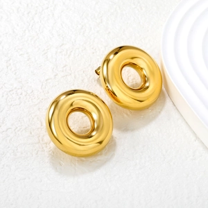 Polished 18k gold plated stainless steel donut hoop earrings on a textured minimalist background