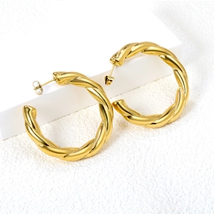 Minimalist gold hollow twisted hoop earrings featuring a stylish geometric metal texture