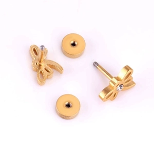 Macro view of gold dragonfly screw back stud earrings featuring clear crystal accents