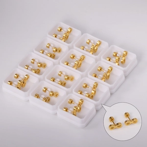 Bulk display of gold infinity symbol stud earrings with flat back screw plugs in white box