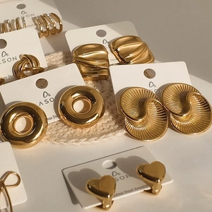 Collection of gold stainless steel geometric earrings with irregular texture on display