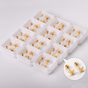 Detailed view of 12 pairs of golden geometric wave earrings in a professional display box
