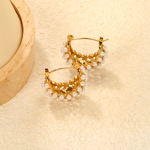 Détail de boucles d'oreilles C plaquées or 18 carats avec perles et motif ajouré