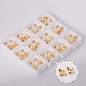 Detail view of 12 boxed golden X-shaped stainless steel earrings with sparkling crystals