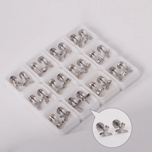 Detail view of 12 pairs of silver stainless steel earrings with cross design and crystals