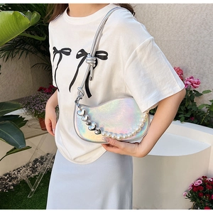 Outdoor shot of a holographic crescent underarm bag with decorative pearl and heart chain