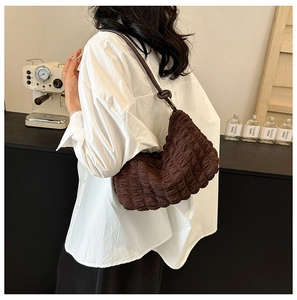 Dettaglio borsa hobo marrone scuro con trama a bolle e tracolla con nodo morbido