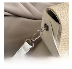 Detail of high-quality silver metal hook and woven straw texture on the box bag