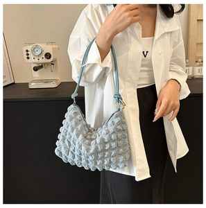 Detail of light blue popcorn textured hobo bag with a stylish pleated finish