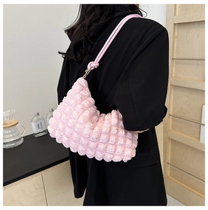 Shoulder view of a light pink bubble texture bag with stylish knotted strap detail