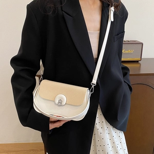 Borsa a sella chic in pelle crema e paglia intrecciata con chiusura metallica in uso