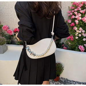 Detail of crescent shoulder bag featuring silver heart link and elegant pearl chain
