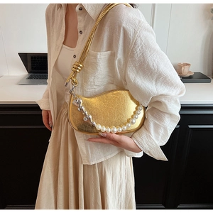 Détail du sac lune doré avec texture métallique craquelée et chaîne cœur perle